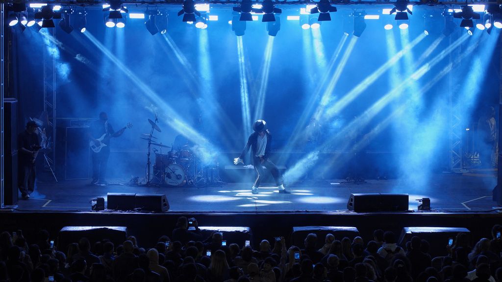 Palco iluminado em azul com o público assistindo