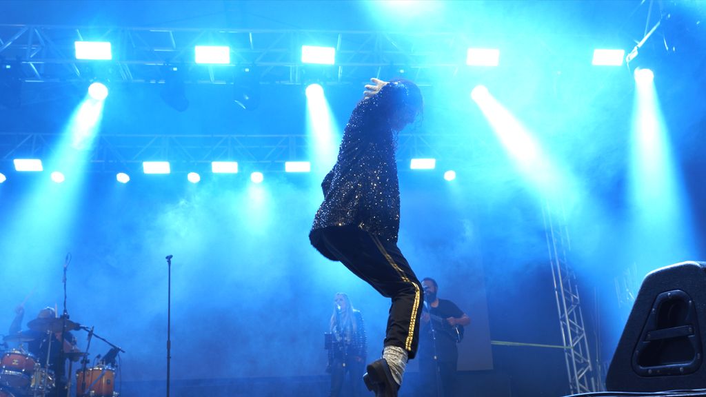Michael James dançando sob luzes azuis