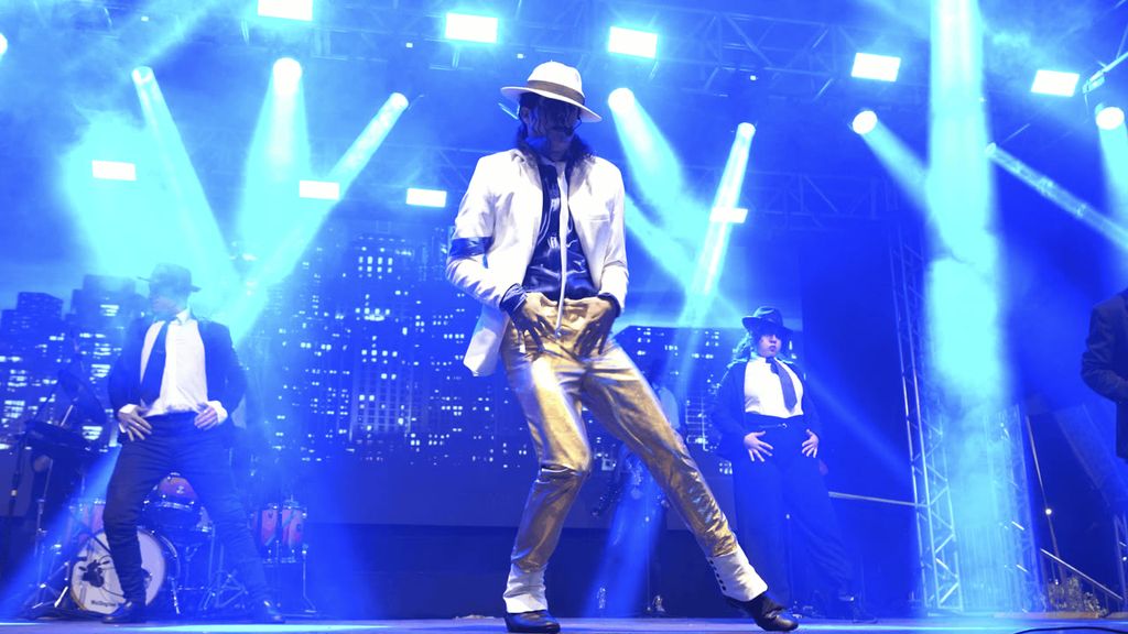 Michael James com figurino branco e calça dourada